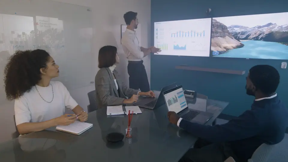 Equipe diversa assiste a uma apresentação numa sala de reunião